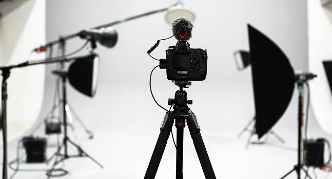 Professional photography and video studio setup with camera, lighting equipment, and softboxes